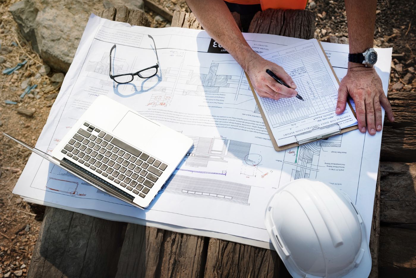Survey plans and a laptop on a table